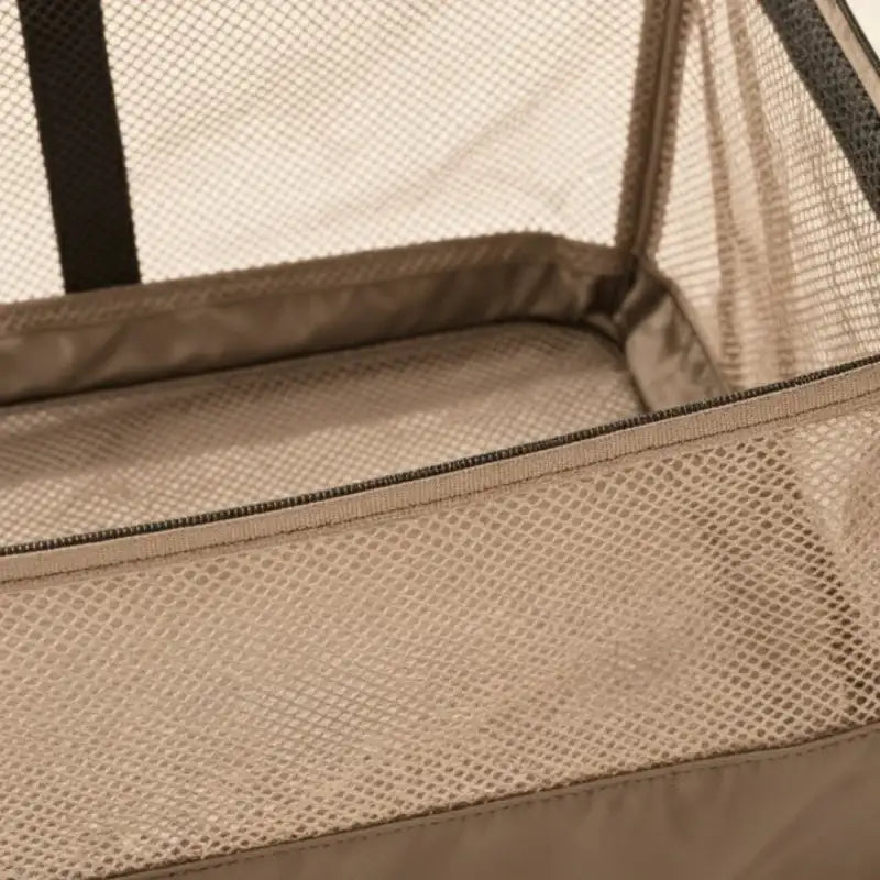 Panier à linge en maille beige avec bordure noire et fermeture éclair.